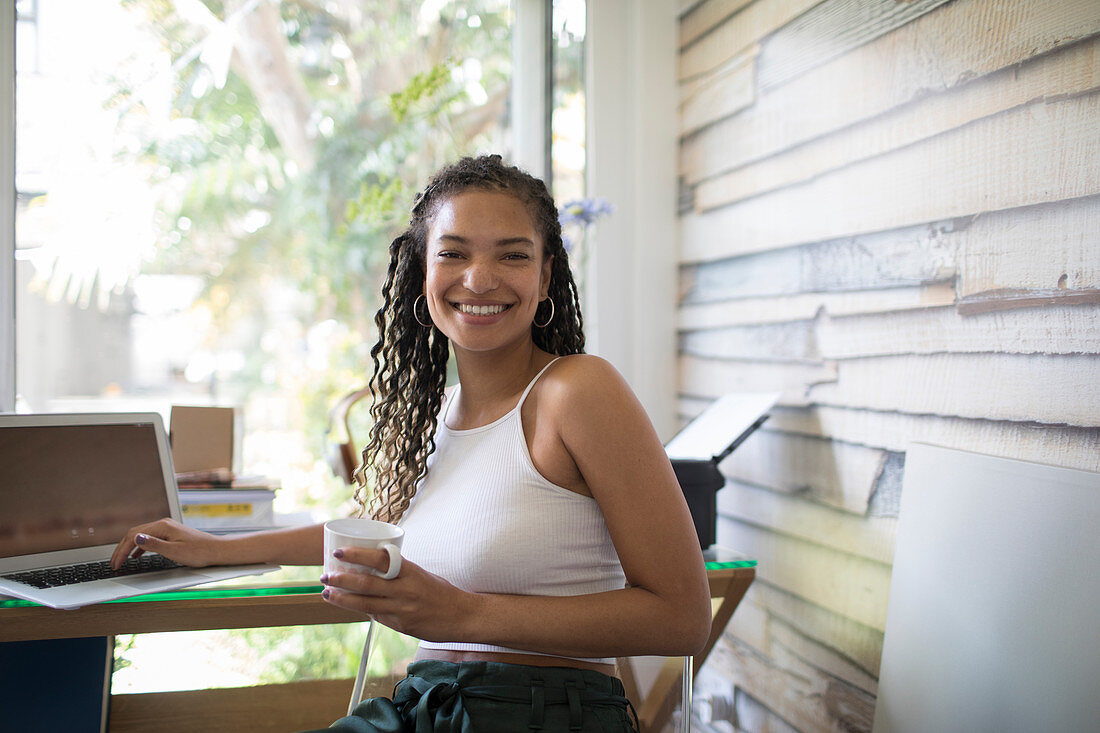 Portrait happy female freelancer working at laptop