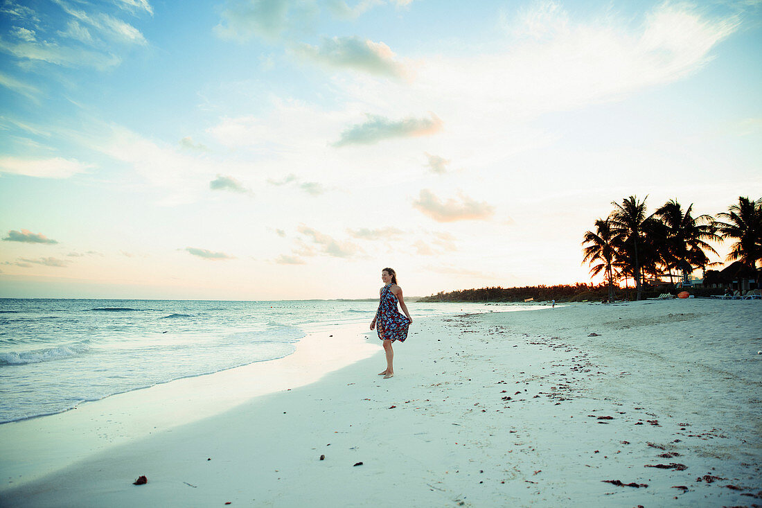 Woman in sun dress on tropical ocean beach Mexico