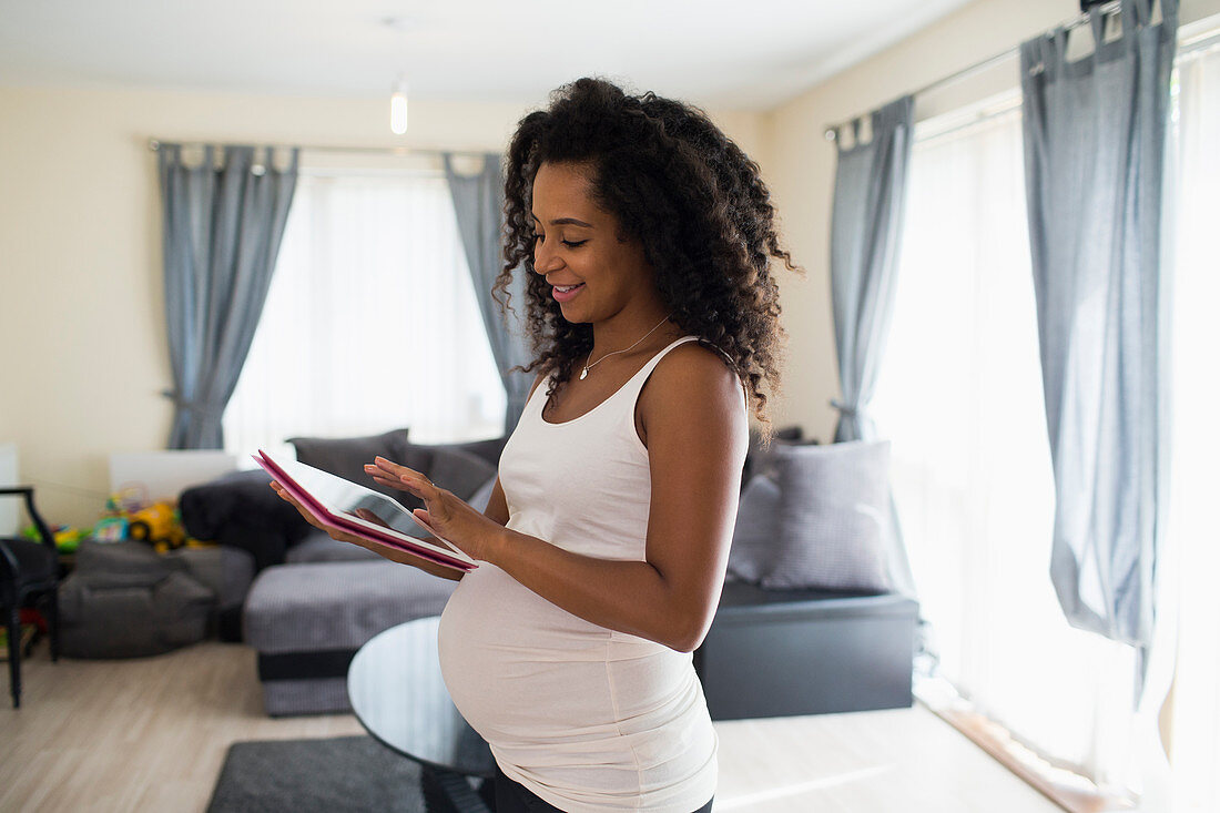Young pregnant woman using digital tablet