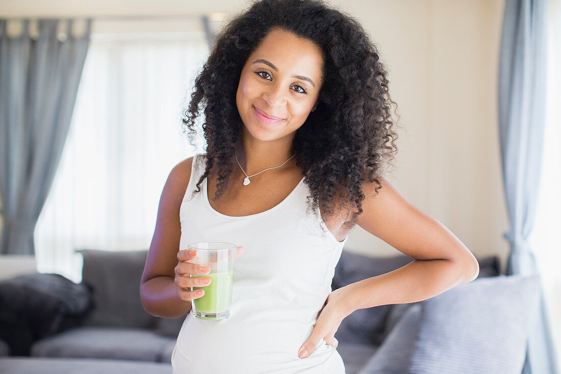 Portrait pregnant woman drinking healthy green smoothie