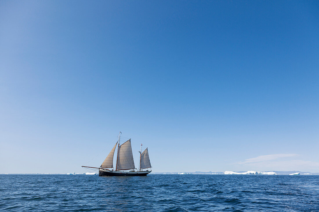 Ship sailing past melting polar ice on blue