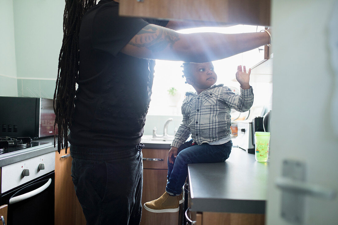 Father and toddler son in apartment kitchen