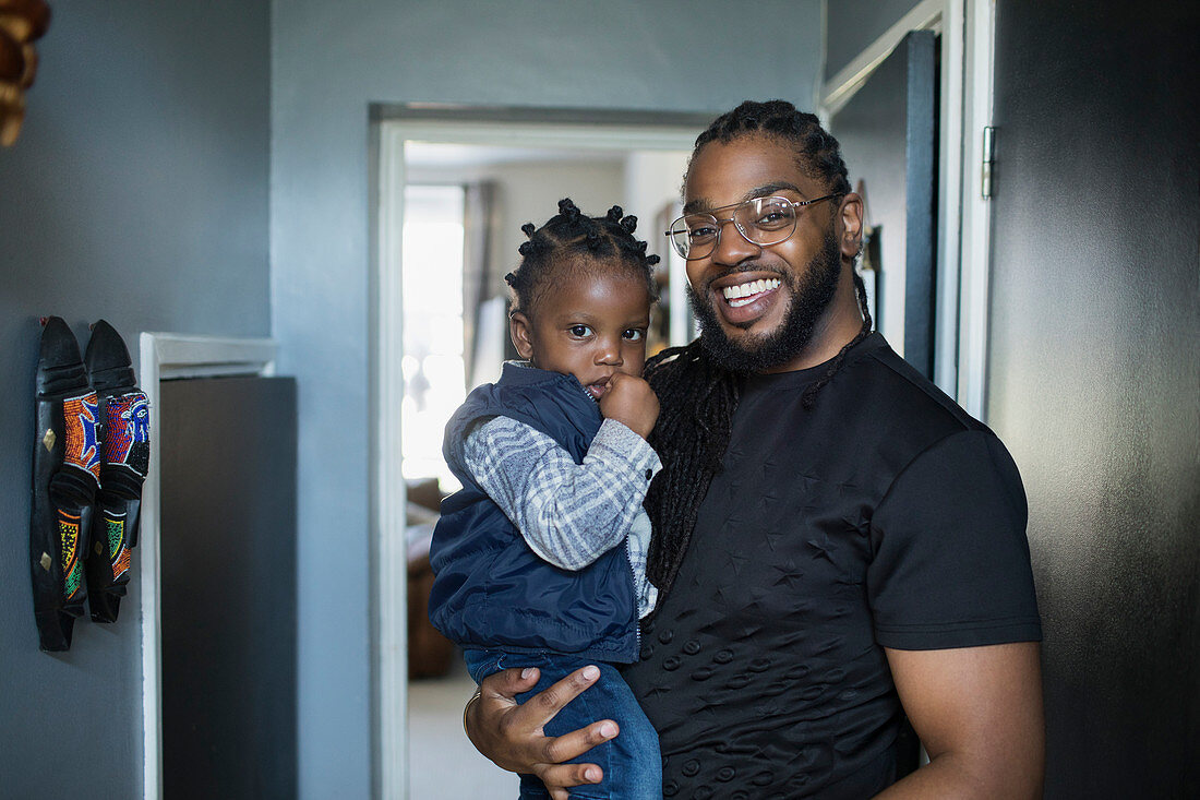 Portrait happy father holding toddler son