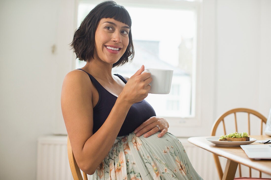 Portrait happy pregnant woman drinking tea