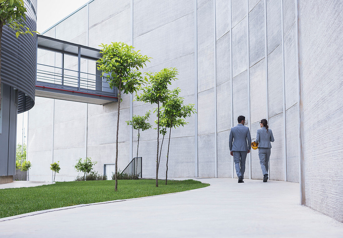 Supervisors walking on sidewalk below building