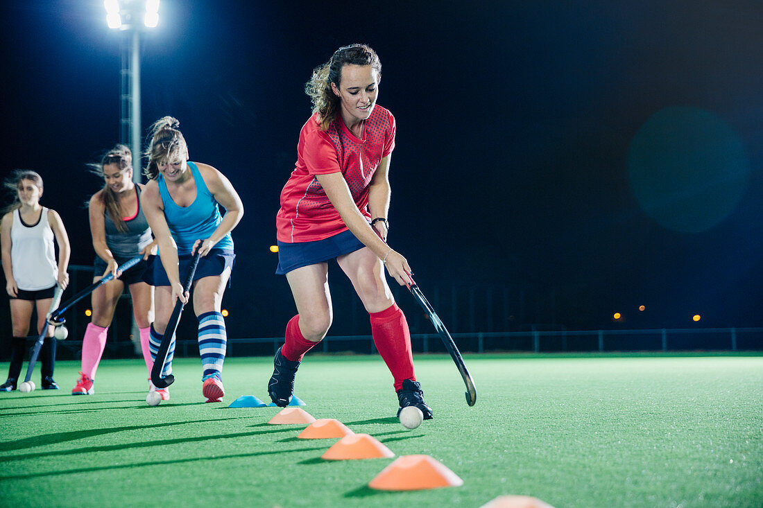 Female hockey player practicing sports drill on field