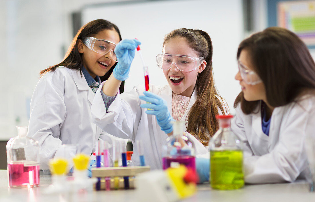 Girl students conducting scientific experiment in classroom