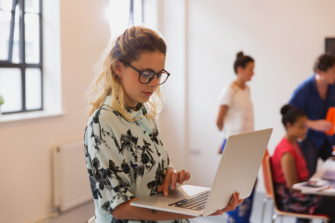 Focused businesswoman using laptop in conference room