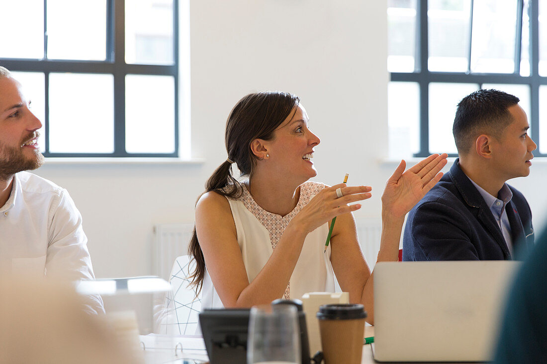 Businesswoman talking, gesturing in conference room meeting