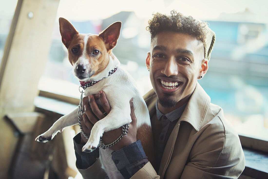 Portrait smiling young man holding dog