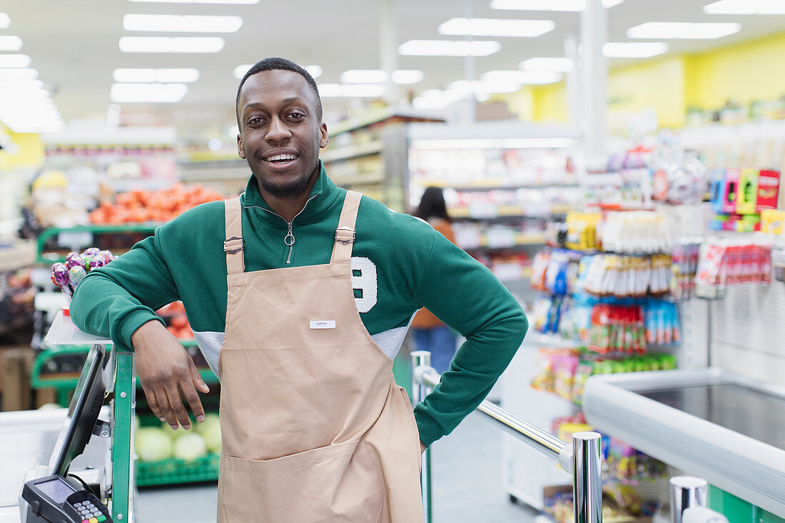 Portrait confident male grocer working in supermarket