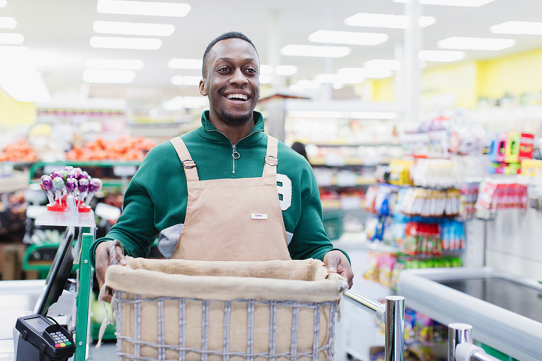 Smiling, confident male grocer working in supermarket