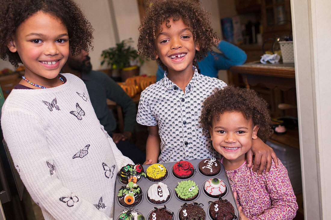 Brother and sisters with decorated Halloween cupcakes