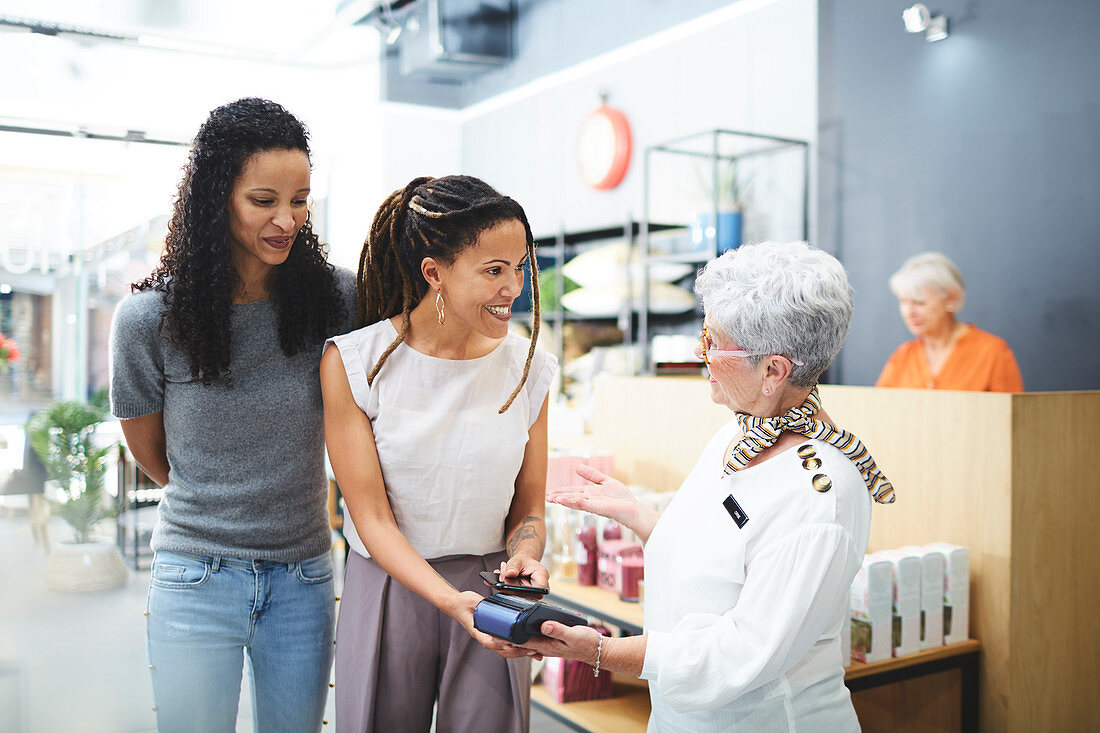 Women paying cashier in home decor shop