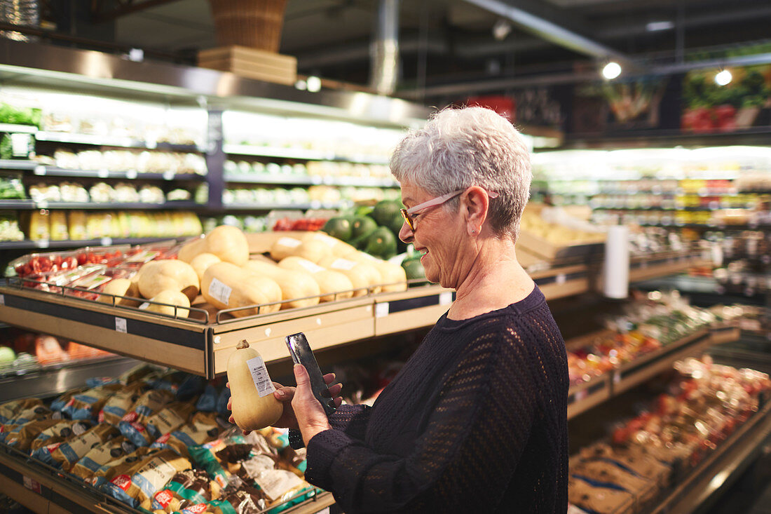 Senior woman shopping in supermarket produce section