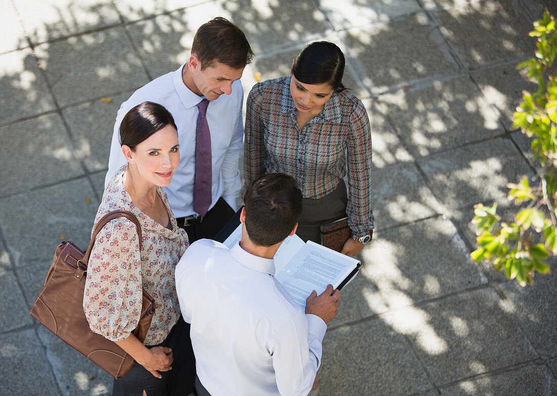 Smiling businesswoman meeting with colleagues outdoors