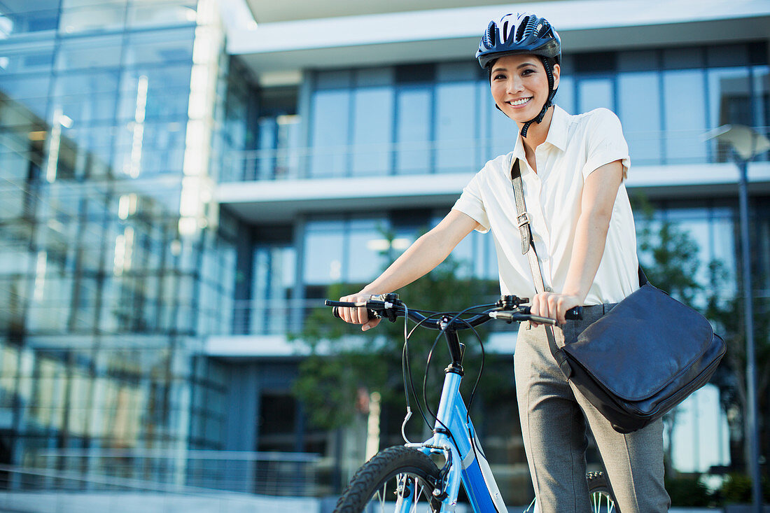 Businesswoman with bicycle outside urban building
