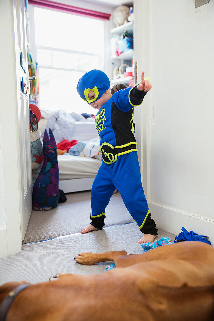Boy in superhero costume playing at home