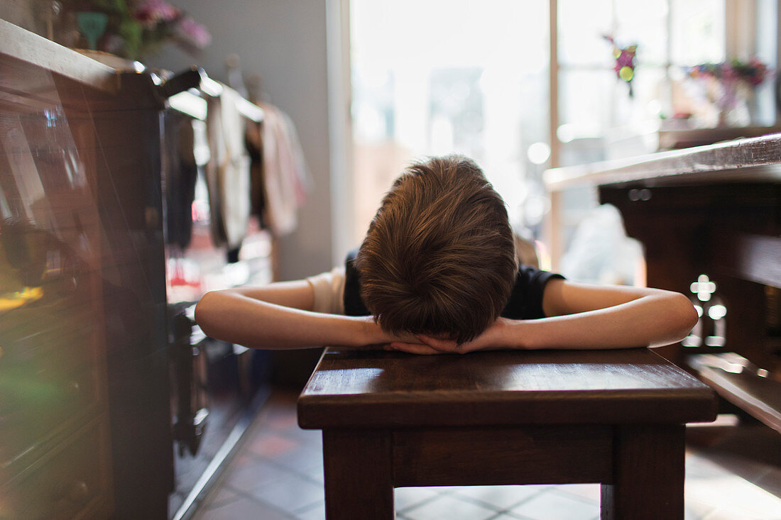 Boy relaxing on bench in kitchen