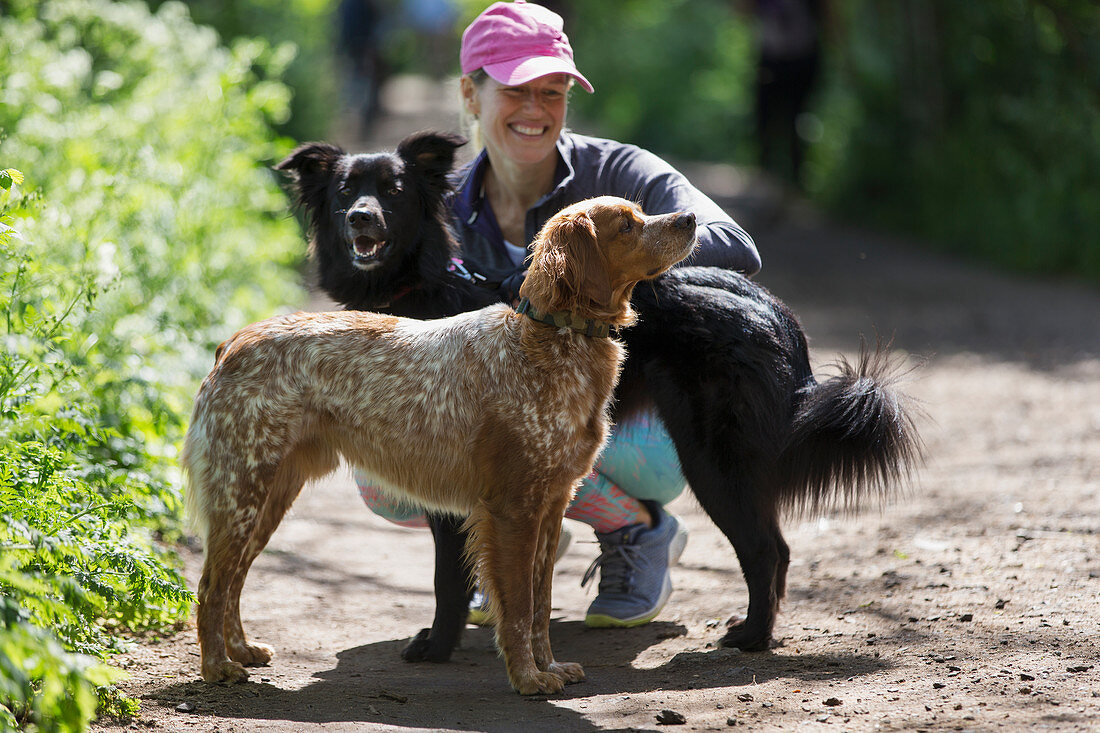 Happy woman with dogs on hiking trail