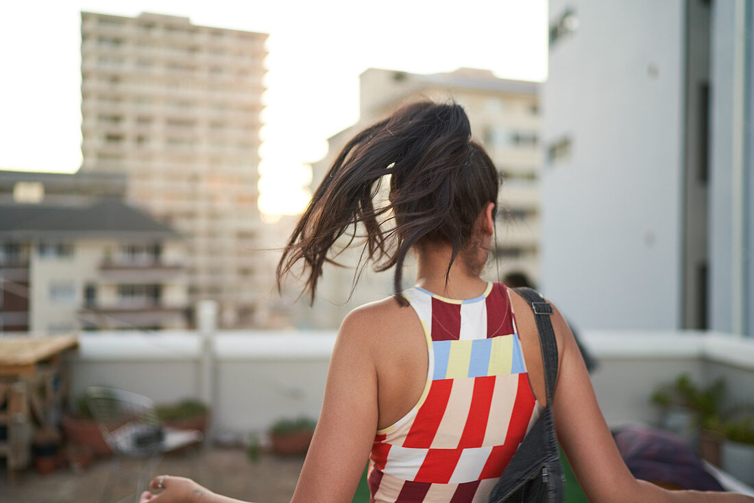 Carefree young woman dancing on urban rooftop