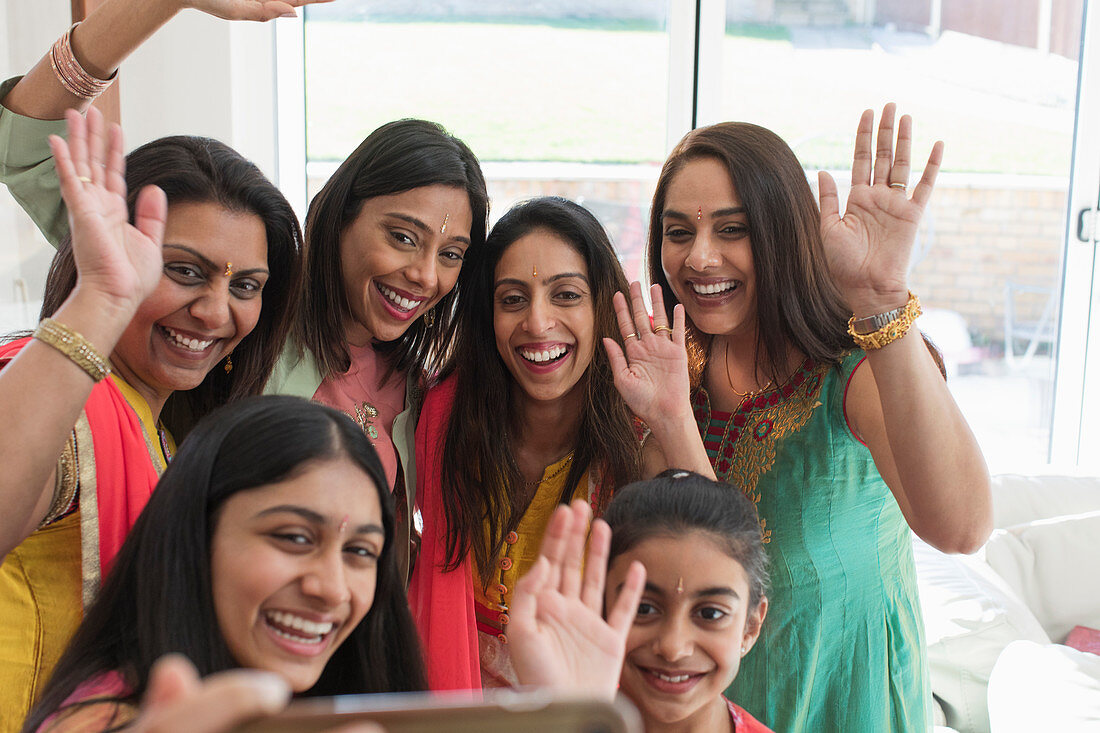 Indian women and girls in saris and bindis taking selfie