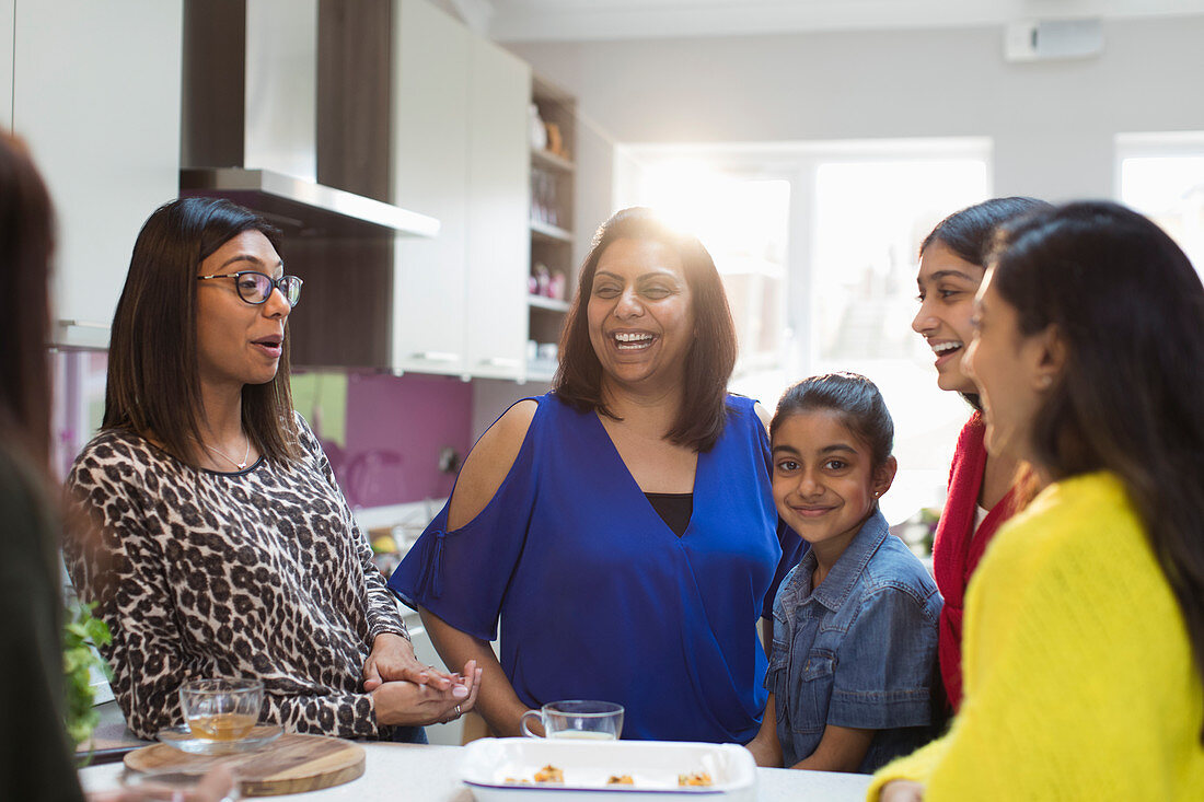 Happy Indian women and girls laughing in kitchen