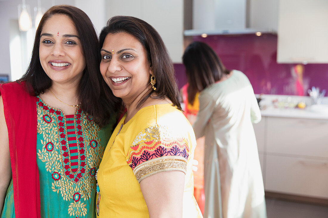 Portrait happy Indian women in saris in kitchen