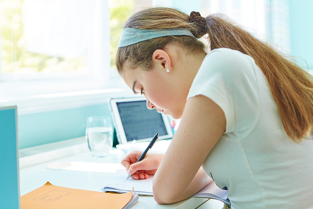 Focused girl doing homework at desk