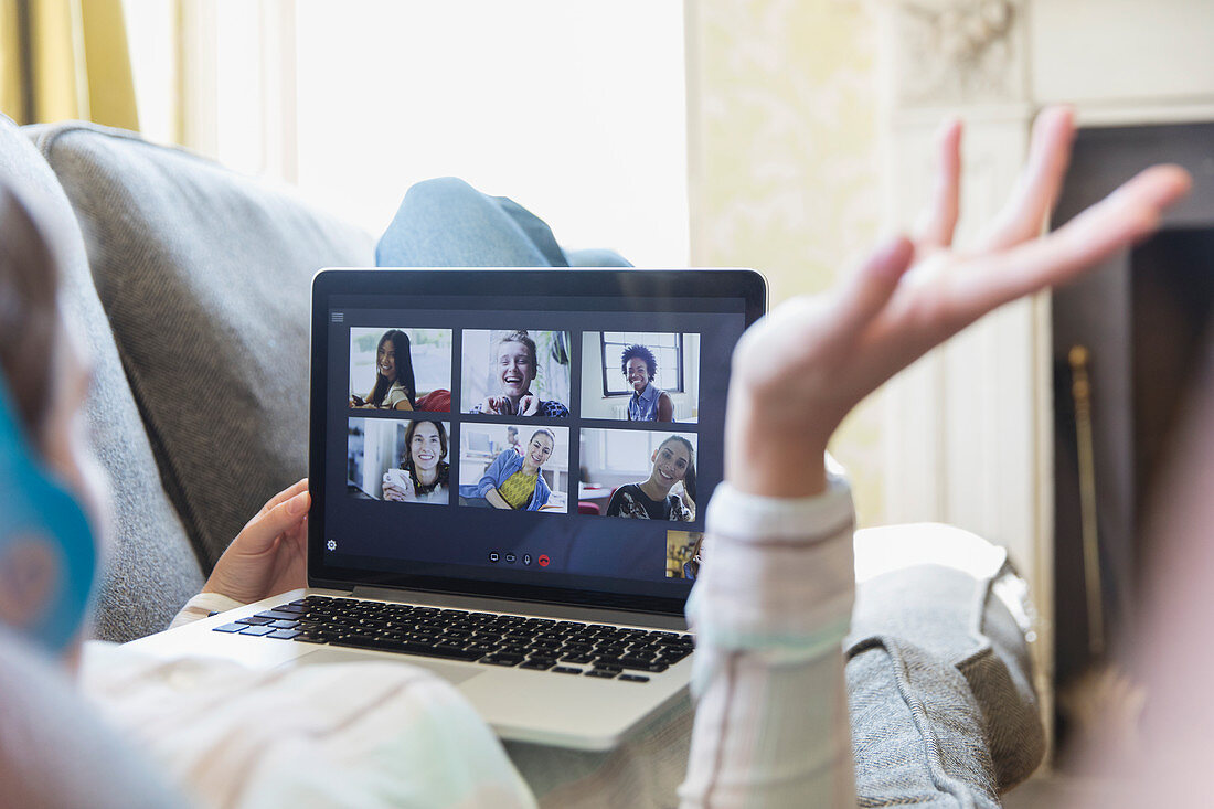 Young friends video chatting on laptop screen on sofa