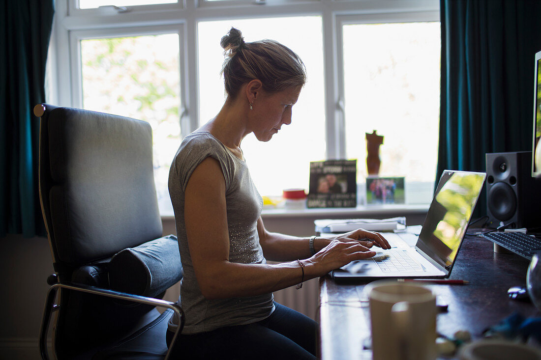Woman working from home at laptop in home office