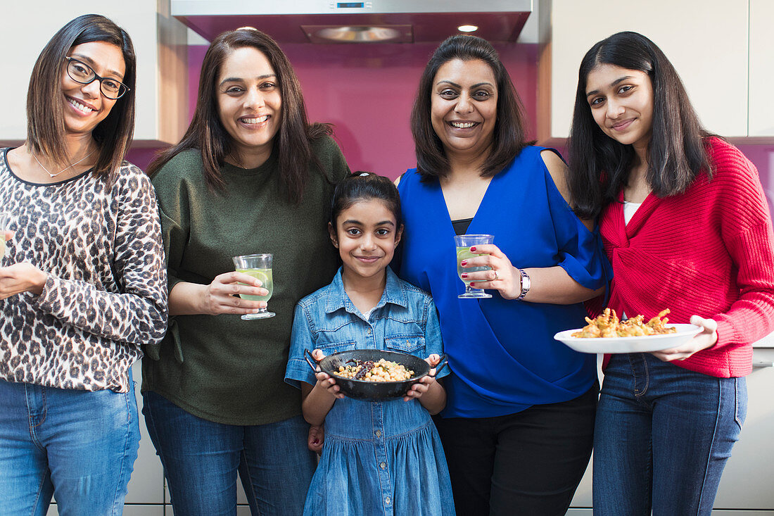 Happy Indian women and girls cooking food in kitchen