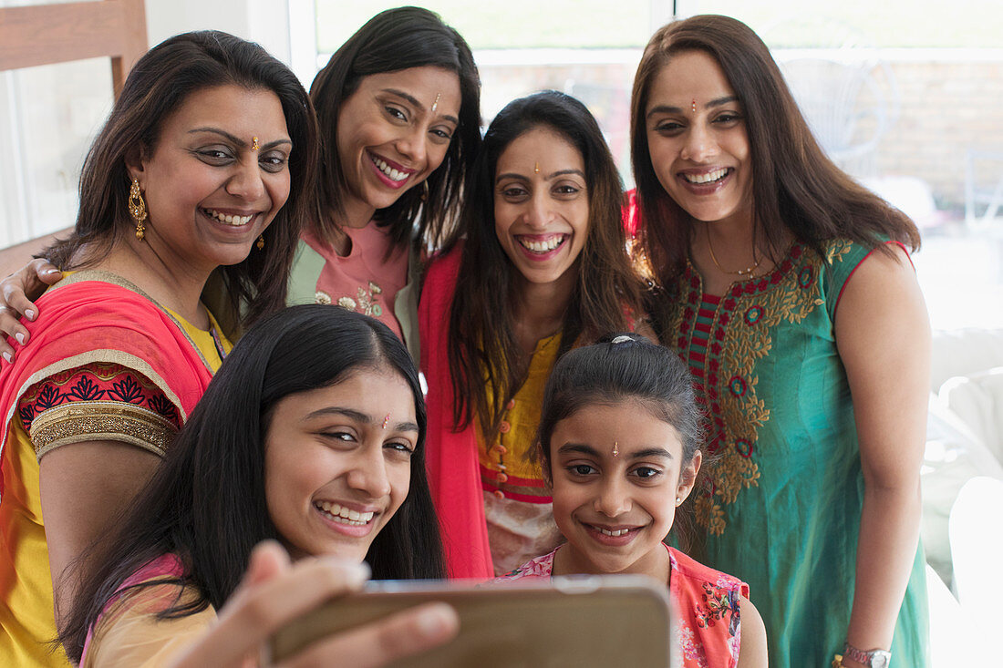 Happy Indian women and girls in saris taking selfie