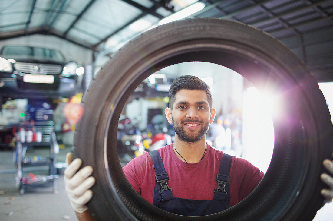 Portrait mechanic holding tire