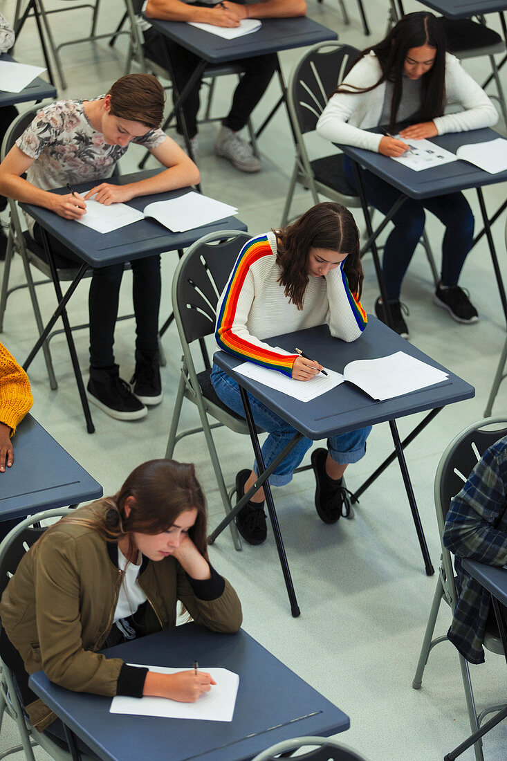 High school students taking exam at tables