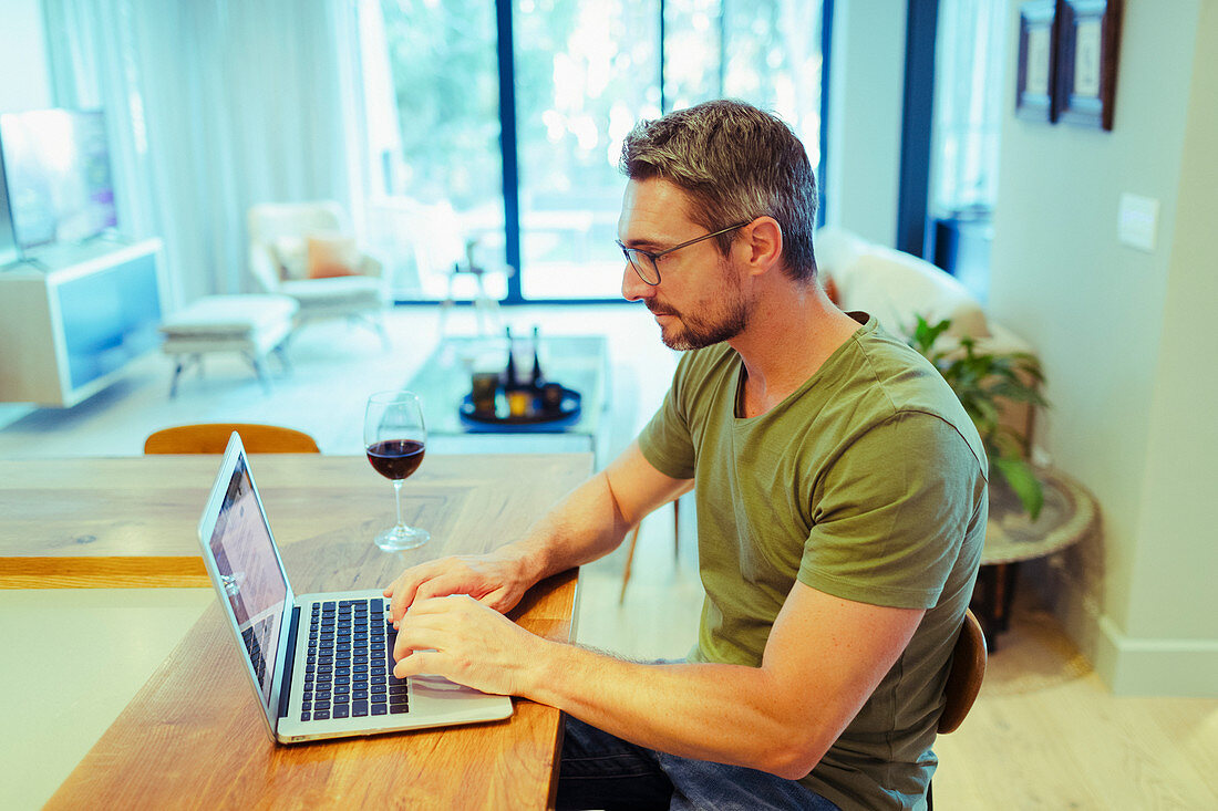 Man working from home, drinking red wine