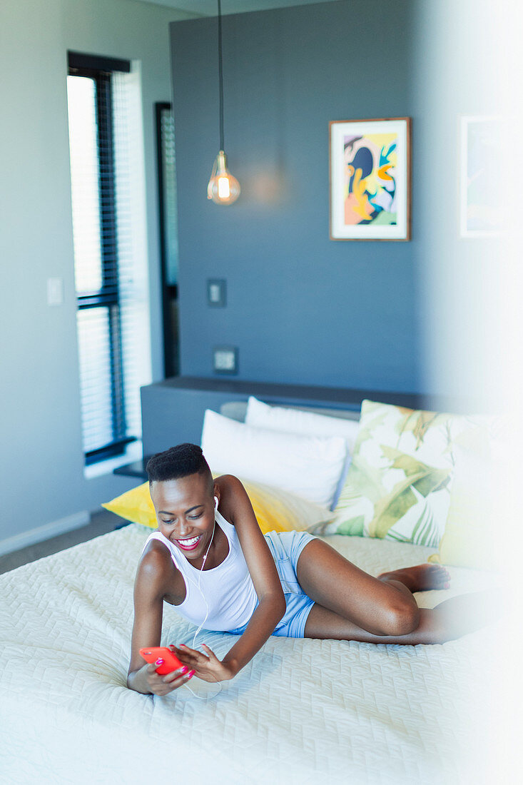 Smiling young woman relaxing on bed