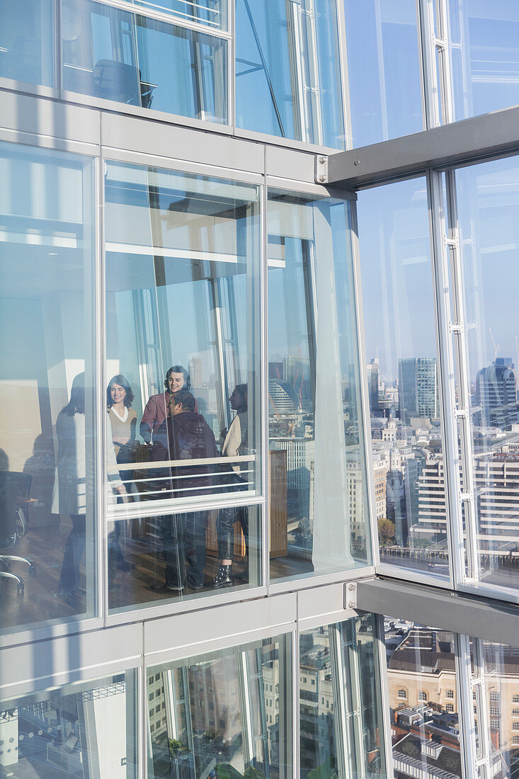 Business people talking at highrise office window