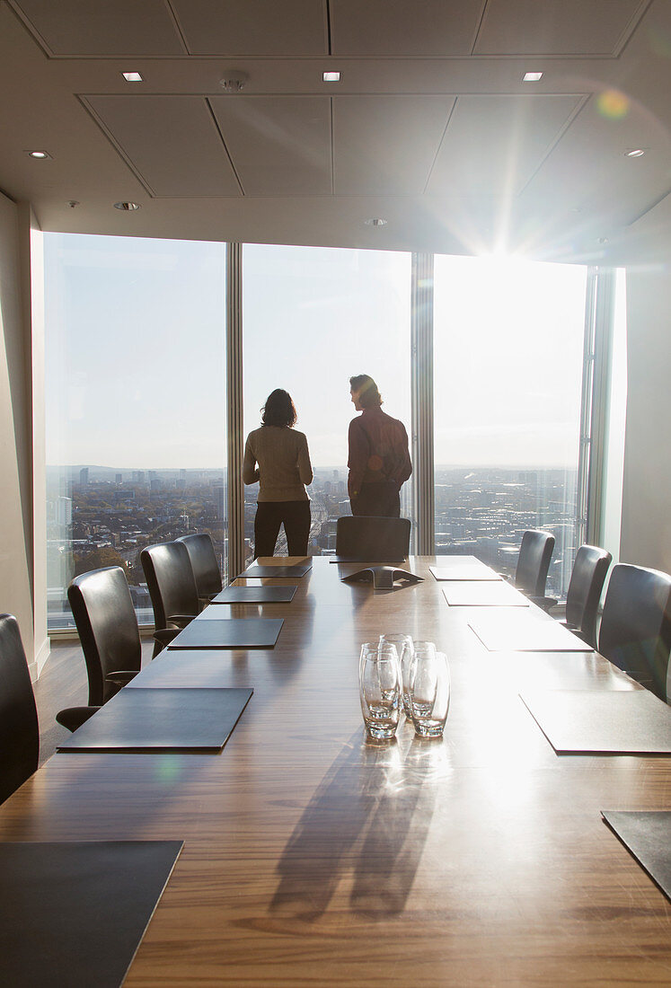 Business people standing at conference room window