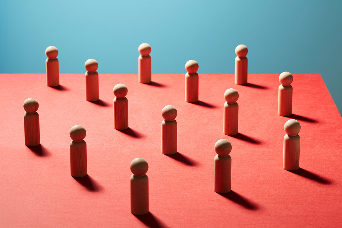 Wooden pawn chess pieces on red surface