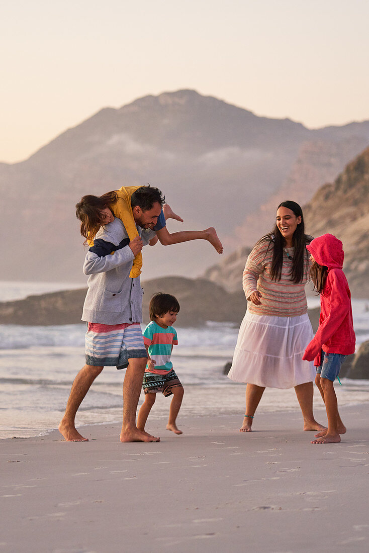 Happy family playing on ocean beach