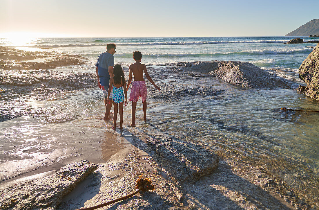 Family walking on ocean beach, South Africa