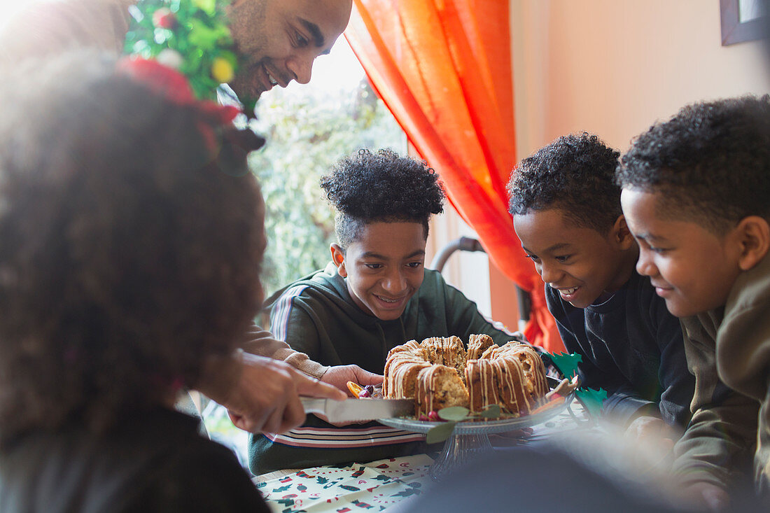 Father serving Christmas cake to eager sons