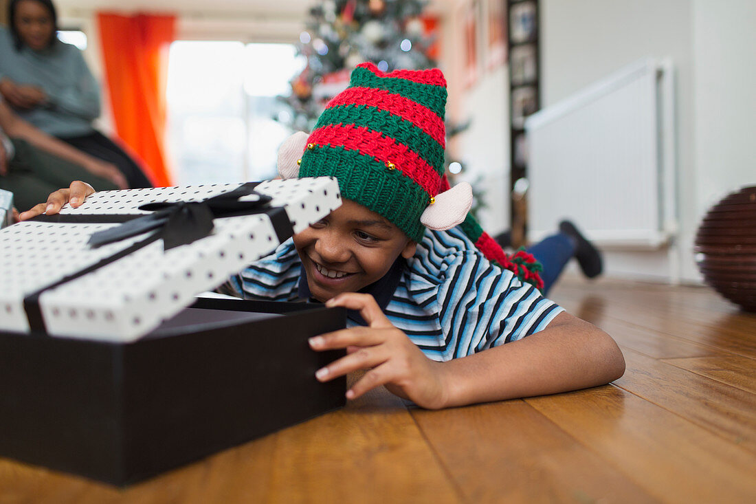 Excited boy opening Christmas gift