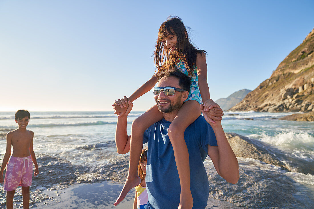 Father carrying daughter on shoulders