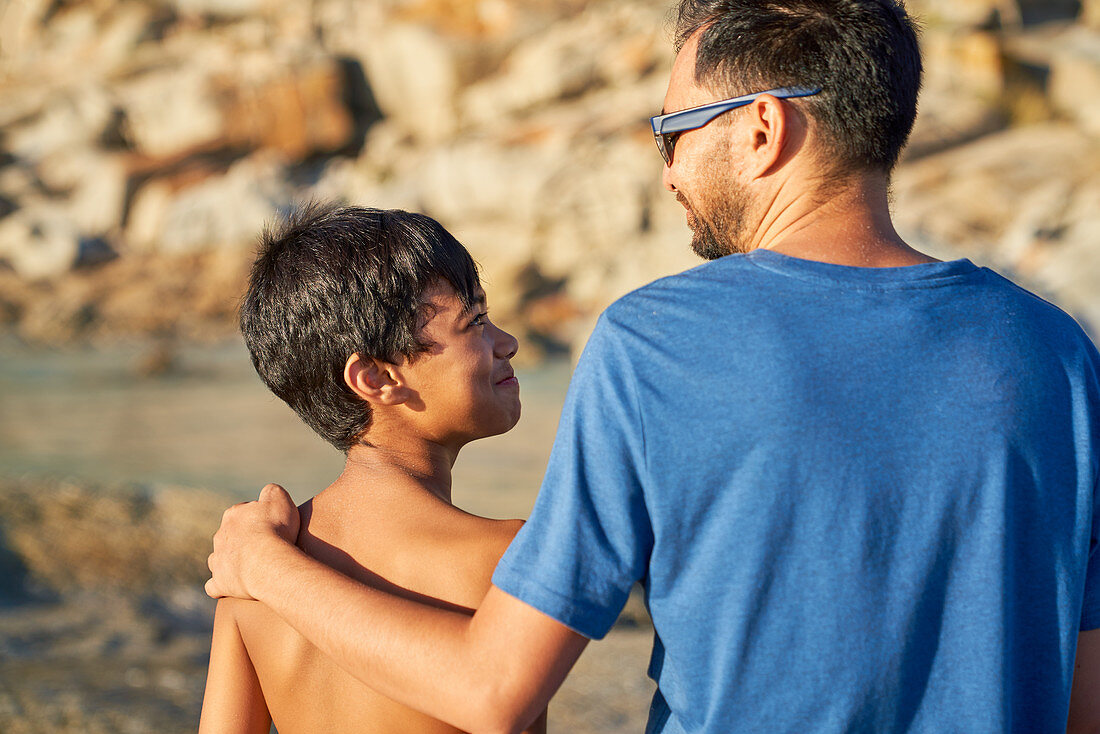 Affectionate father and son on sunny beach