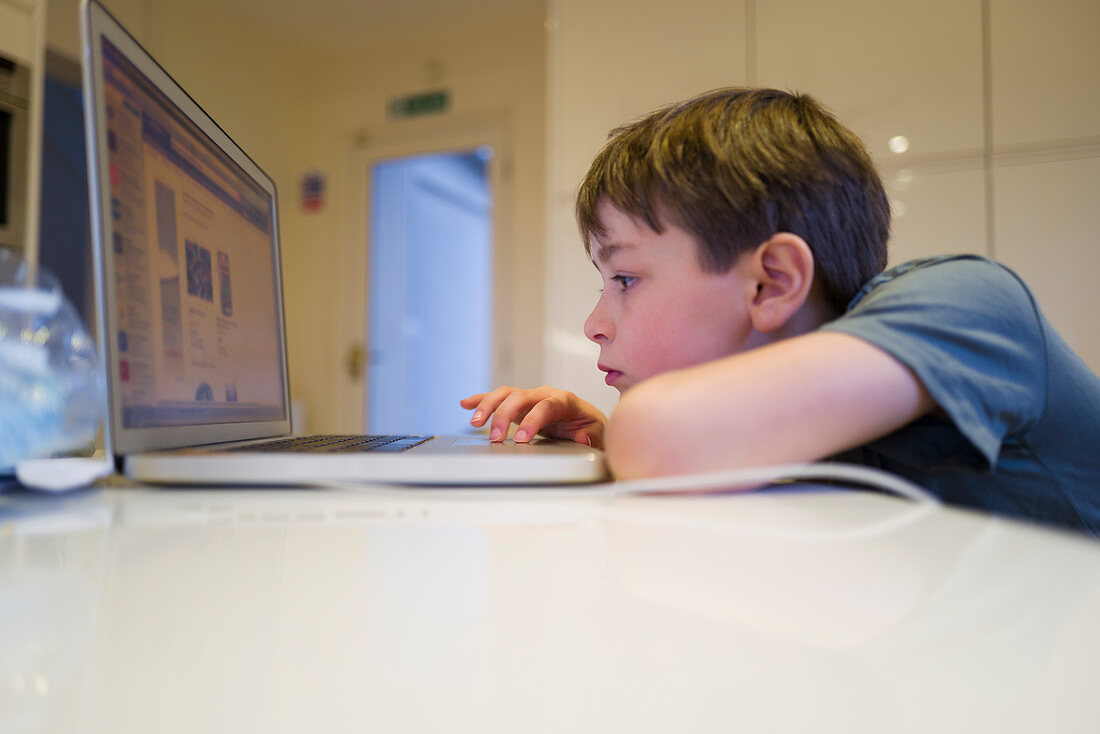 Boy home-schooling at laptop