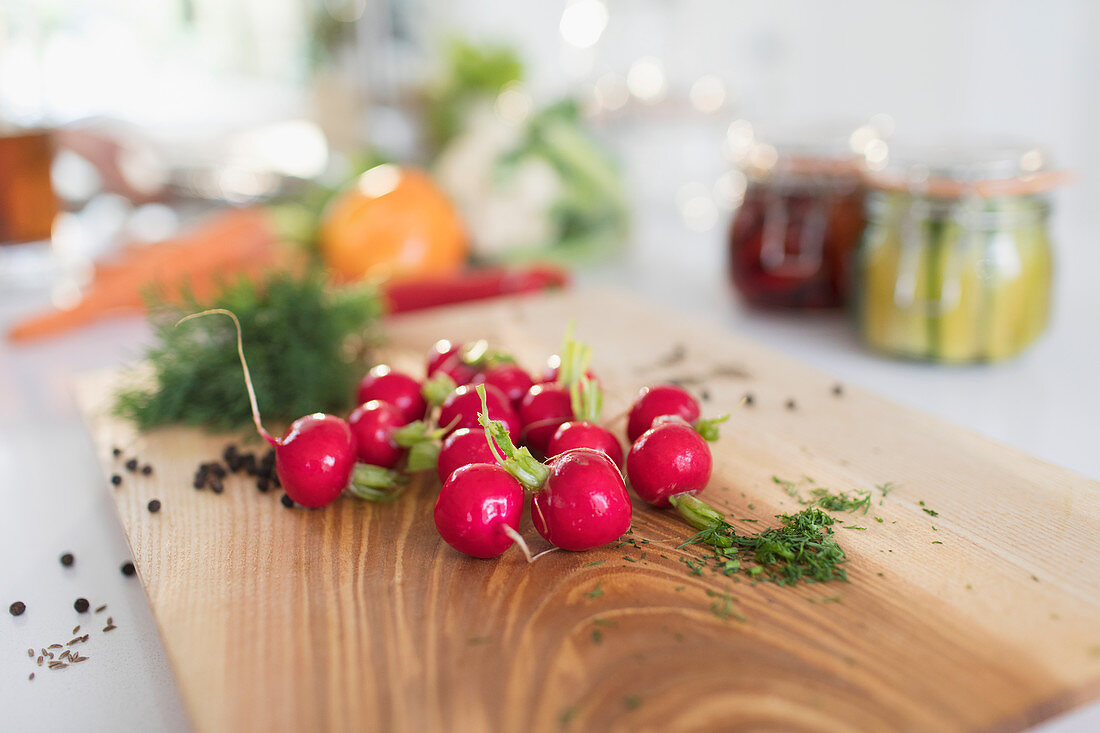 Close up red radishes and herbs on cutting board