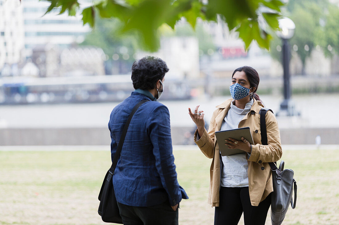 Business people with face masks talking