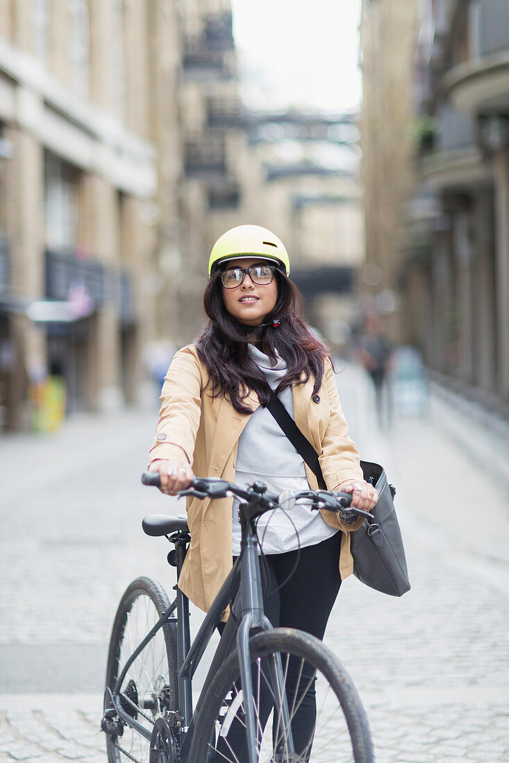 Portrait businesswoman with bicycle on city street
